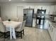 Well-lit kitchen featuring white cabinets, stainless steel appliances, granite countertops, and a dining table at 4602 N 47Th N Ave, Phoenix, AZ 85031