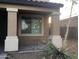 A close-up of a welcoming front porch with decorative columns and a small garden area at 4722 S 238Th Ln, Buckeye, AZ 85326