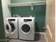 Modern laundry room with full size washer and dryer and shelf at 4722 S 238Th Ln, Buckeye, AZ 85326