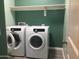 Functional laundry room with modern white appliances and overhead shelving at 4722 S 238Th Ln, Buckeye, AZ 85326