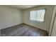 A bright bedroom with neutral paint, laminate flooring and a window with vertical blinds at 4752 W Palo Verde Dr, Glendale, AZ 85301