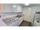 A bright galley kitchen featuring white cabinets, stainless steel sink and faucet and laminate countertops at 4752 W Palo Verde Dr, Glendale, AZ 85301