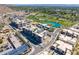 Aerial view of a community showcasing modern buildings, a lush golf course, and a serene lake at 4849 N Camelback Ridge Rd # B403, Scottsdale, AZ 85251