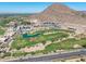 Scenic aerial view of a golf course community with mountain views, modern homes, and lush greenery at 4849 N Camelback Ridge Rd # B403, Scottsdale, AZ 85251