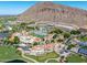 Aerial view of a resort showcasing pools, villas, golf course, and mountain backdrop at 4849 N Camelback Ridge Rd # B403, Scottsdale, AZ 85251