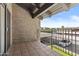 View of the covered balcony with a tiled floor and views of the parking area on a sunny day at 5525 E Thomas Rd # K16, Phoenix, AZ 85018