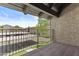 View from a covered balcony overlooking a green space with trees and a parking area on a sunny day at 5525 E Thomas Rd # K16, Phoenix, AZ 85018