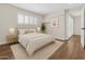 Bedroom features wood floors, white trim, a window with blinds, and a queen-sized bed at 5525 E Thomas Rd # K16, Phoenix, AZ 85018