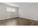 Unfurnished bedroom features wood flooring, white trim, and a window letting in natural light at 5525 E Thomas Rd # K16, Phoenix, AZ 85018