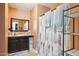 Functional bathroom with a framed mirror, under-sink storage, and a shower featuring a stylish geometric curtain at 5615 W Camelback Rd, Phoenix, AZ 85031