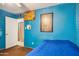 Bedroom featuring blue accent walls, a comfortable bed, and a door leading to an adjacent room or closet at 5615 W Camelback Rd, Phoenix, AZ 85031