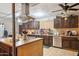 Open concept kitchen with stainless steel appliances, central island, and dark wood cabinetry at 5615 W Camelback Rd, Phoenix, AZ 85031