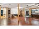 Open-concept living room with rich wood floors, featuring a large screen and seamless flow to the kitchen at 5615 W Camelback Rd, Phoenix, AZ 85031