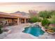 Luxurious backyard featuring a rock waterfall pool, spa, covered patio, and mountain views at 5921 E Leisure Ln, Carefree, AZ 85377