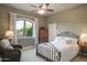 Comfortable bedroom with a wrought iron bed frame and a cozy reading nook by the arched window at 5921 E Leisure Ln, Carefree, AZ 85377