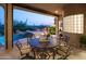 Covered patio with a dining set overlooking a pool and desert landscape at 5921 E Leisure Ln, Carefree, AZ 85377