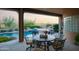 Covered patio with outdoor dining and lounge area overlooking the pool and desert landscape at 5921 E Leisure Ln, Carefree, AZ 85377