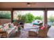 Inviting covered patio with comfortable seating, a ceiling fan, and views of the pool and lush garden at 5921 E Leisure Ln, Carefree, AZ 85377