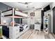 A bedroom with a bunk bed, desk, and light wood plank flooring at 597 S 221St Dr, Buckeye, AZ 85326