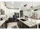 Bright kitchen with dark kitchen island, modern appliances, and granite countertops offers a great design at 597 S 221St Dr, Buckeye, AZ 85326