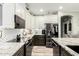 Modern kitchen with stainless steel appliances, granite countertops, and white cabinetry, great for cooking at 597 S 221St Dr, Buckeye, AZ 85326