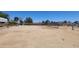 Fenced backyard with dirt ground and perimeter fencing under a blue sky at 6104 W Marconi Ave, Glendale, AZ 85306