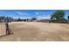 Wide shot of backyard with dirt ground, perimeter fencing, sheds, and vehicles at 6104 W Marconi Ave, Glendale, AZ 85306