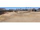 Wide shot of backyard with dirt ground, perimeter fencing, a house, and sheds at 6104 W Marconi Ave, Glendale, AZ 85306