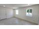 Bright living room with tile flooring, neutral walls, two windows, and white door at 6104 W Marconi Ave, Glendale, AZ 85306