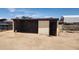 Concrete block storage shed with a dark wooden door under a bright blue sky at 6104 W Marconi Ave, Glendale, AZ 85306