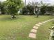 Grassy backyard featuring mature trees and a brick paver pathway at 6637 E Culver St, Scottsdale, AZ 85257