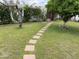Grassy backyard featuring mature trees and a brick paver pathway at 6637 E Culver St, Scottsdale, AZ 85257