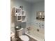 Charming blue bathroom with decorative white shelves, unique mirror and a bathtub at 6637 E Culver St, Scottsdale, AZ 85257
