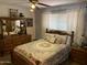 Comfortable bedroom with floral bedding, wood furniture, and a large window for natural light at 6637 E Culver St, Scottsdale, AZ 85257