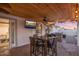 This covered patio includes a TV, a dining table, and an outdoor grill at 6901 E Oak St, Scottsdale, AZ 85257