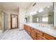 Bright bathroom featuring a double sink vanity, large mirrors, and a shower at 6940 W Willow Ave, Peoria, AZ 85381
