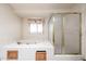 Bathroom with a white tub, a window, and a shower at 6940 W Willow Ave, Peoria, AZ 85381