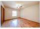 A bedroom featuring natural light from the window, wood floors, and a ceiling fan at 6940 W Willow Ave, Peoria, AZ 85381