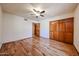 Bright bedroom with wood floors, a ceiling fan, and a wooden closet at 6940 W Willow Ave, Peoria, AZ 85381