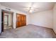 Bedroom featuring neutral carpet, a ceiling fan, closet space, and adjoining doorway at 6940 W Willow Ave, Peoria, AZ 85381