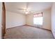 Bedroom with neutral carpet, ceiling fan, a large window, and closet space at 6940 W Willow Ave, Peoria, AZ 85381