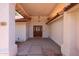 Inviting front entry with a covered porch, decorative lighting, and a stylish wooden door, enhancing curb appeal at 6940 W Willow Ave, Peoria, AZ 85381