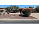 Well-maintained home featuring desert landscaping with mature trees and shrubs, complementing the red tile roof at 6940 W Willow Ave, Peoria, AZ 85381