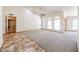 Bright living room featuring arched windows, neutral carpeting, a ceiling fan, and tile flooring in a spacious layout at 6940 W Willow Ave, Peoria, AZ 85381