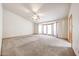 Spacious living room featuring natural light, a ceiling fan, and neutral carpet at 6940 W Willow Ave, Peoria, AZ 85381