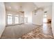 Bright living room with arched windows, neutral carpet, a ceiling fan, and tile flooring leading to a brick fireplace at 6940 W Willow Ave, Peoria, AZ 85381