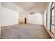 Open living room with vaulted ceilings, ceiling fan, and large windows at 6940 W Willow Ave, Peoria, AZ 85381