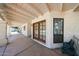 Inviting covered patio featuring textured walls, wooden beamed roof, and stylish French doors for indoor-outdoor living at 6940 W Willow Ave, Peoria, AZ 85381