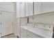 Functional laundry room featuring a stacked washer and dryer, ample storage cabinets, and tiled floors at 7006 E Jensen St # 48, Mesa, AZ 85207