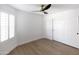 Bright bedroom featuring wood floors, white walls, shutters, ceiling fan and closet with sliding doors at 802 N Lisbon Dr, Chandler, AZ 85226